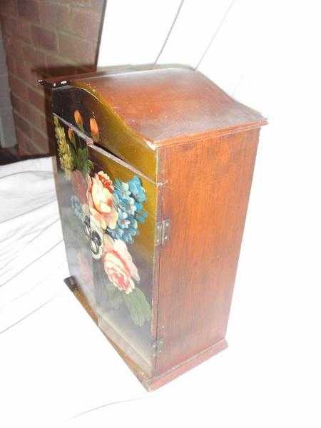 A small floral painted table top cabinet