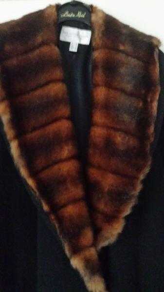 A VERY HEAVY WARM WINTER COAT. IT IS IN BLACK WITH  FUR TRIM .