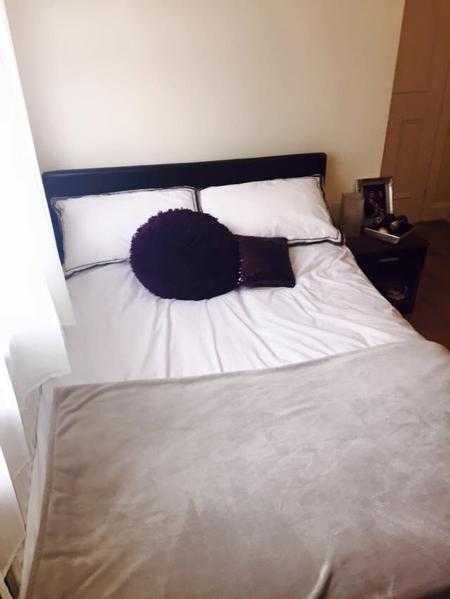 Black faux leather double bed and mattress.