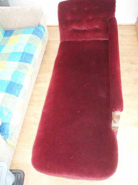 Chaise longue VictorianEdwardian sofa. Dark red velvet fabric. Moves on castors.