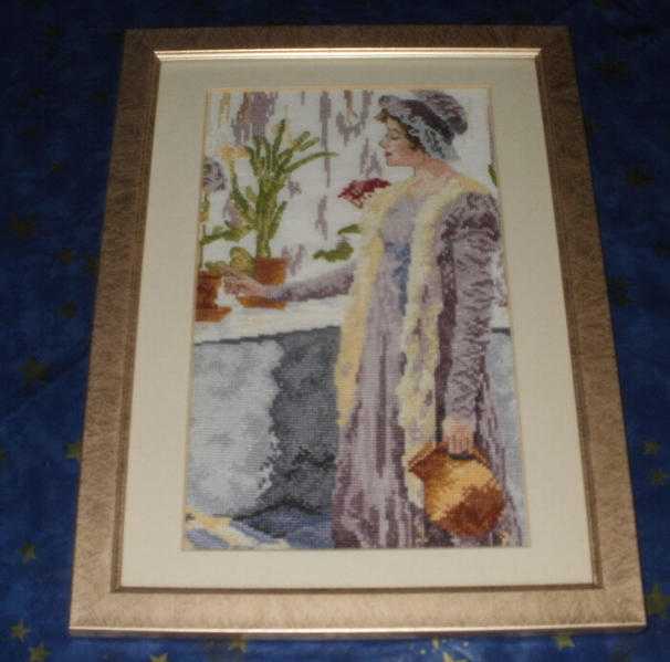 Cross stitch picture of a lady framed