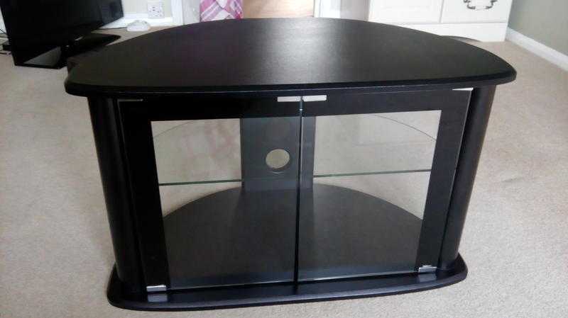 Curved black TV unit with glass doors and shelf