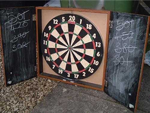 Darts board in cabinet with chalk board both sides