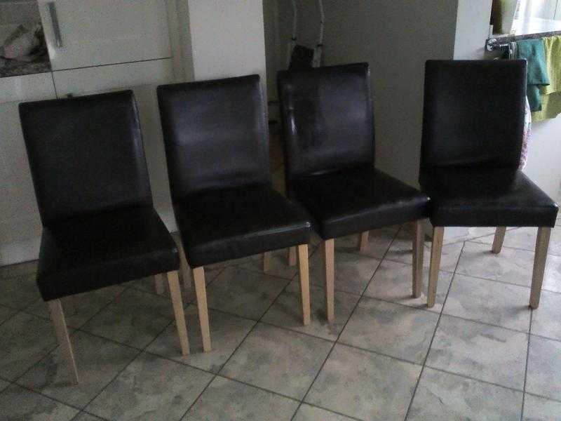 Four brown leather dining chairs