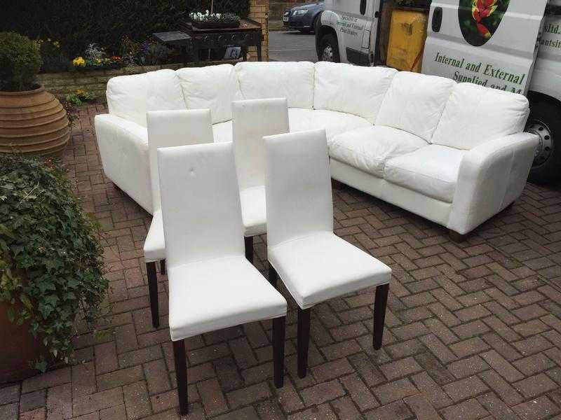 Four matching white upholstered dining chairs with covers.