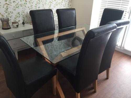 Glass dining table with oak legs  6 leather look chairs