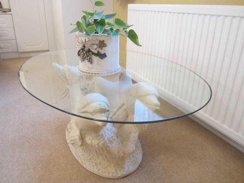 Glass top coffee table with dolphin base design