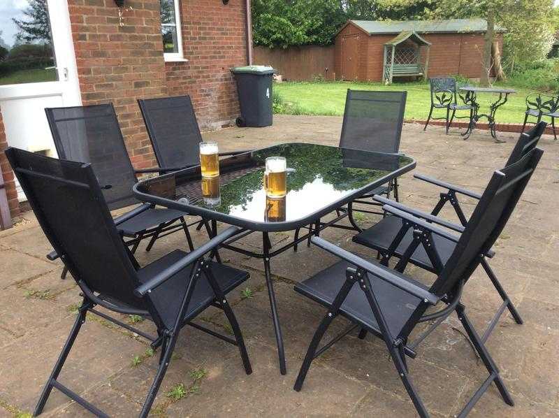 Patio table, 6 black chairs, umbrella and stand.