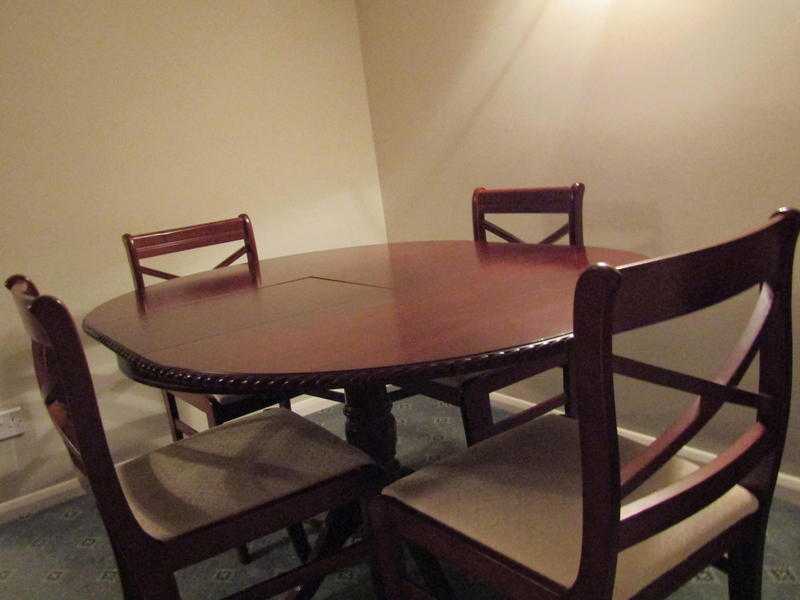 Round extending table with four chairs in Mahogany