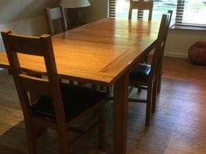 Solid dark oak extendable dining table and six chairs