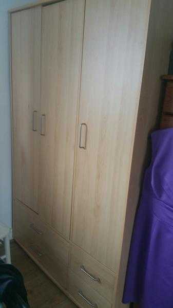 Triple wardrobe in light wood effect. 4 drawers underneath