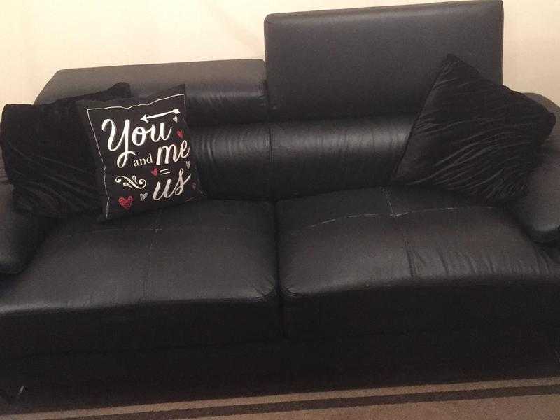 Two black leather three seater sofas