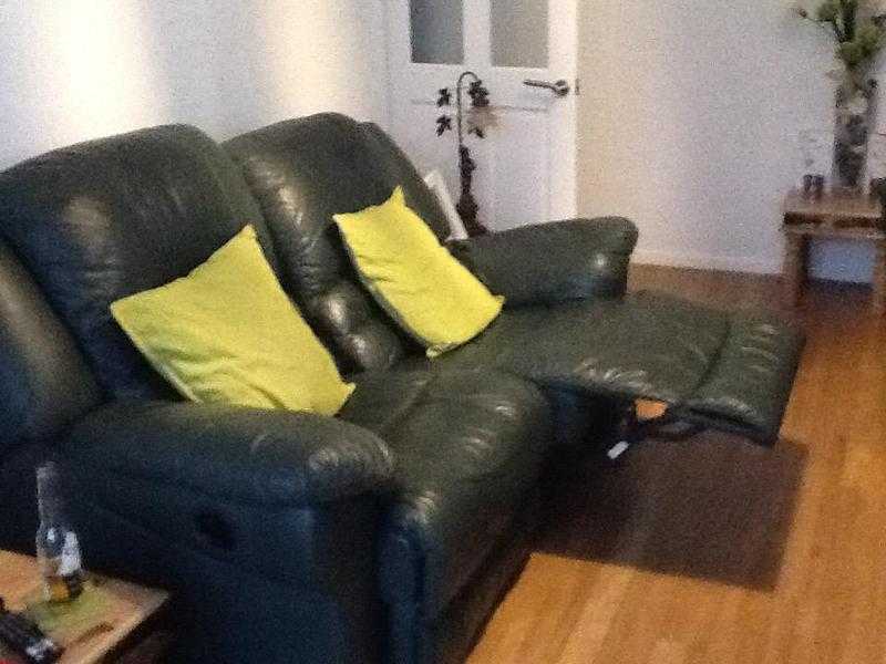 Two seater green leather sofa and two chairs