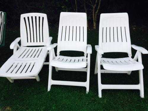 White plastic recliner chairs plus sun lounger