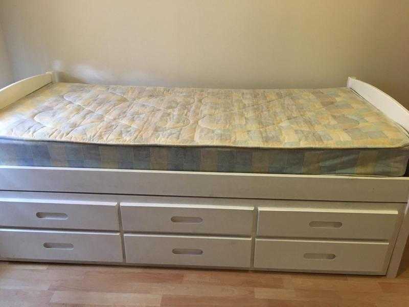 White wooden guest bed with storage drawers