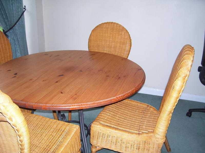 woodern top dinning table and four wicker chairs